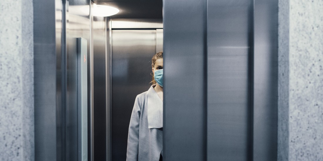 Women in a lift wearing a facemask.